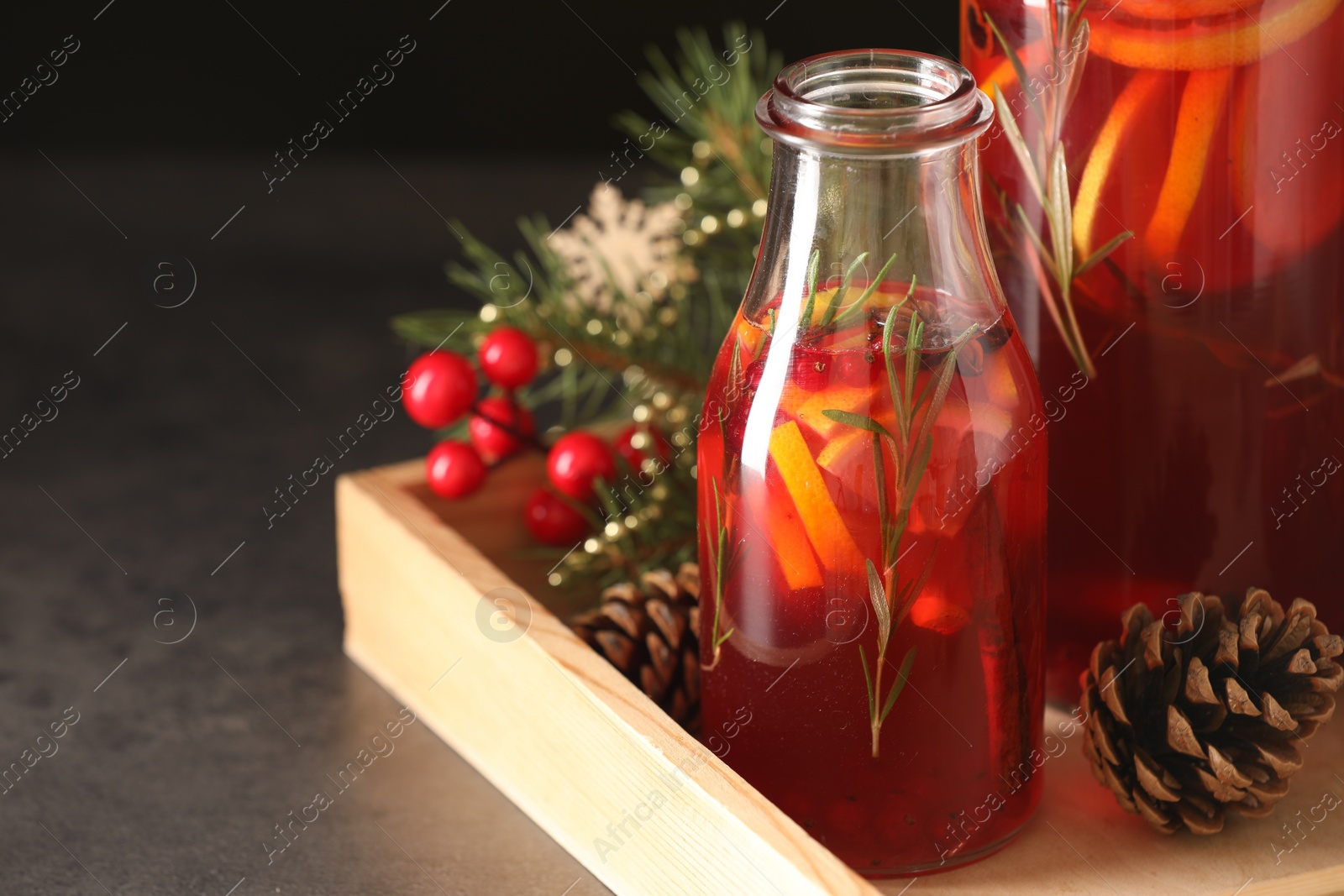 Photo of Aromatic punch drink and Christmas decor on grey table, closeup. Space for text