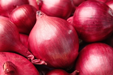 Photo of Fresh whole red onions as background, closeup