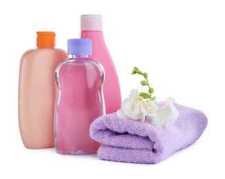 Photo of Baby oil, toiletries and flowers on white background
