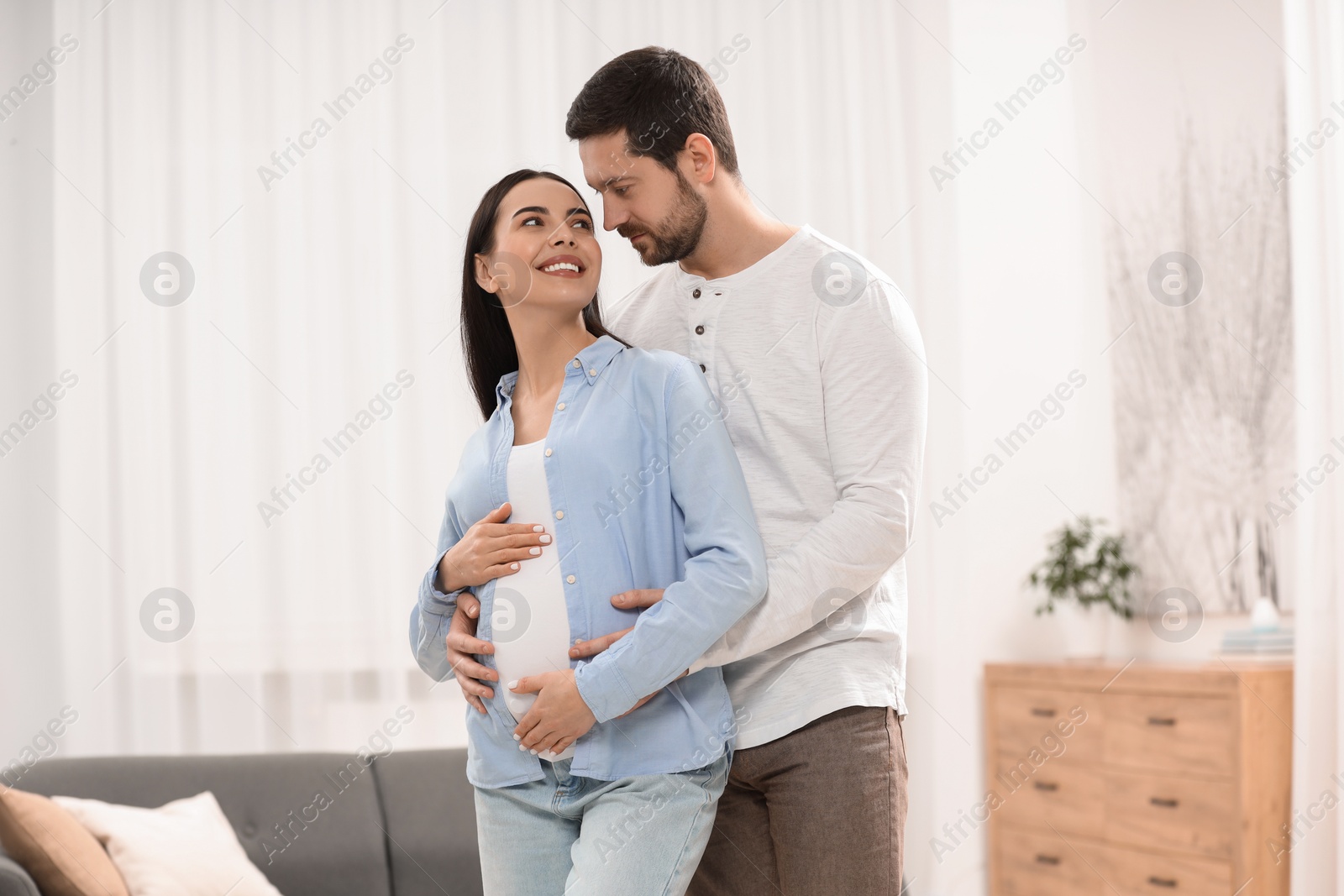 Photo of Happy pregnant woman with her husband at home