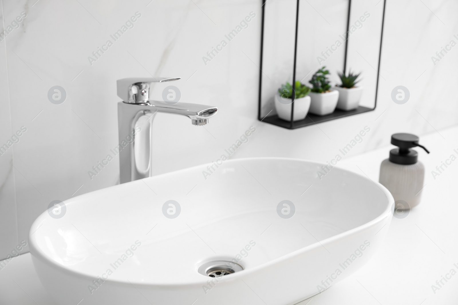 Photo of Stylish vessel sink on bathroom counter. Interior design