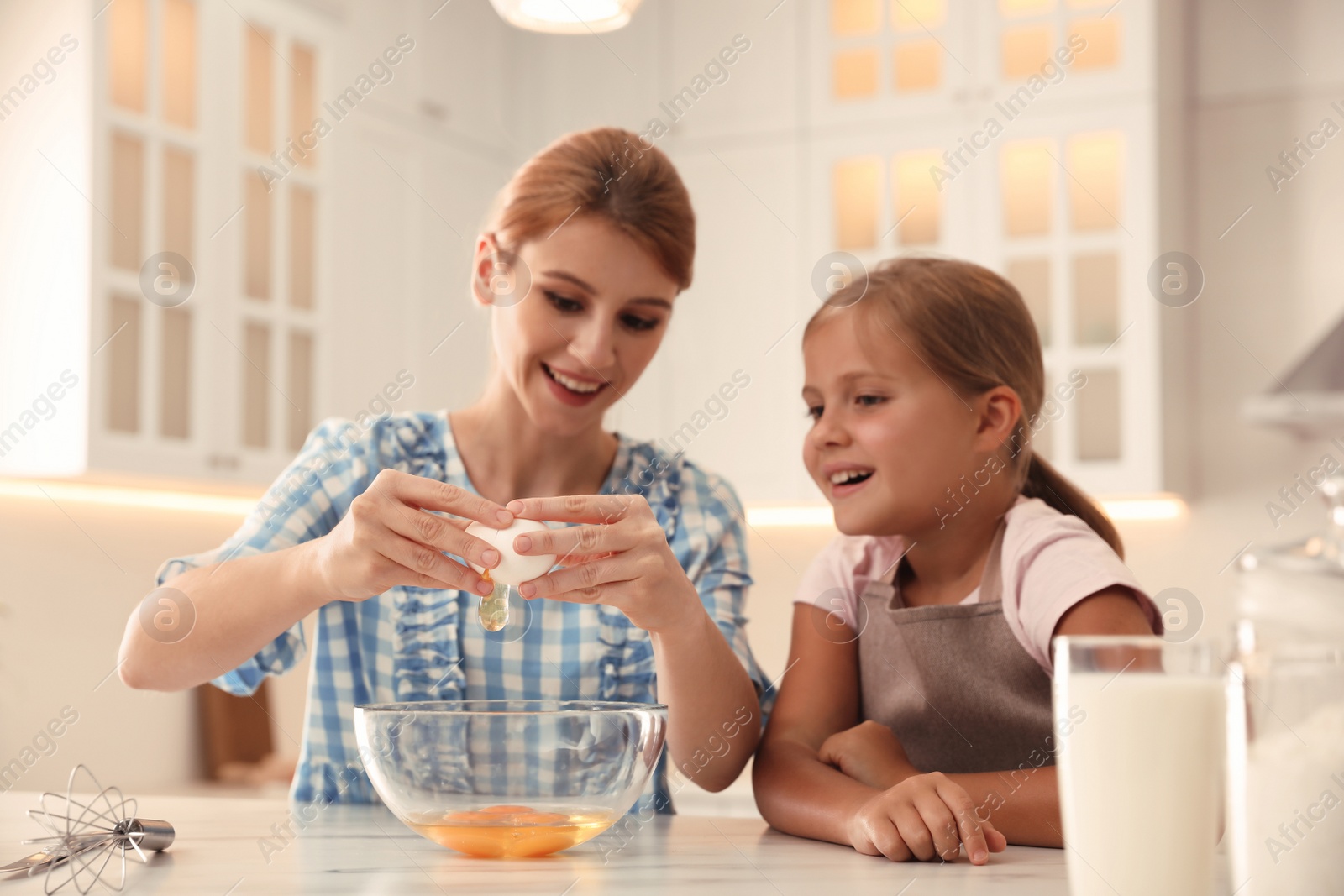 Photo of Mother and daughter making dough together in kitchen