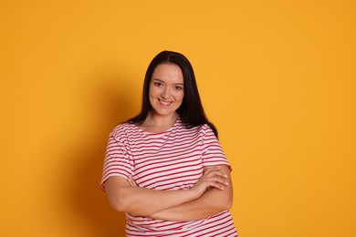 Beautiful overweight woman with charming smile on yellow background