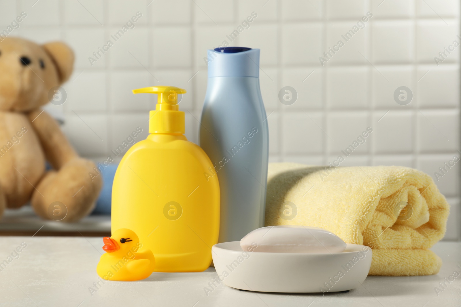 Photo of Baby cosmetic products, bath duck and towel on white table