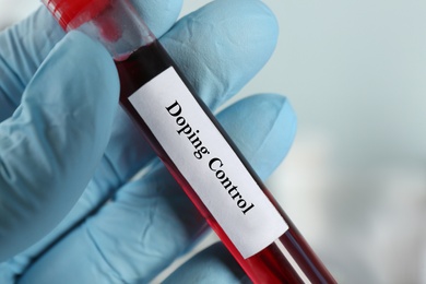 Image of Doctor holding test tube with sample, closeup. Doping control
