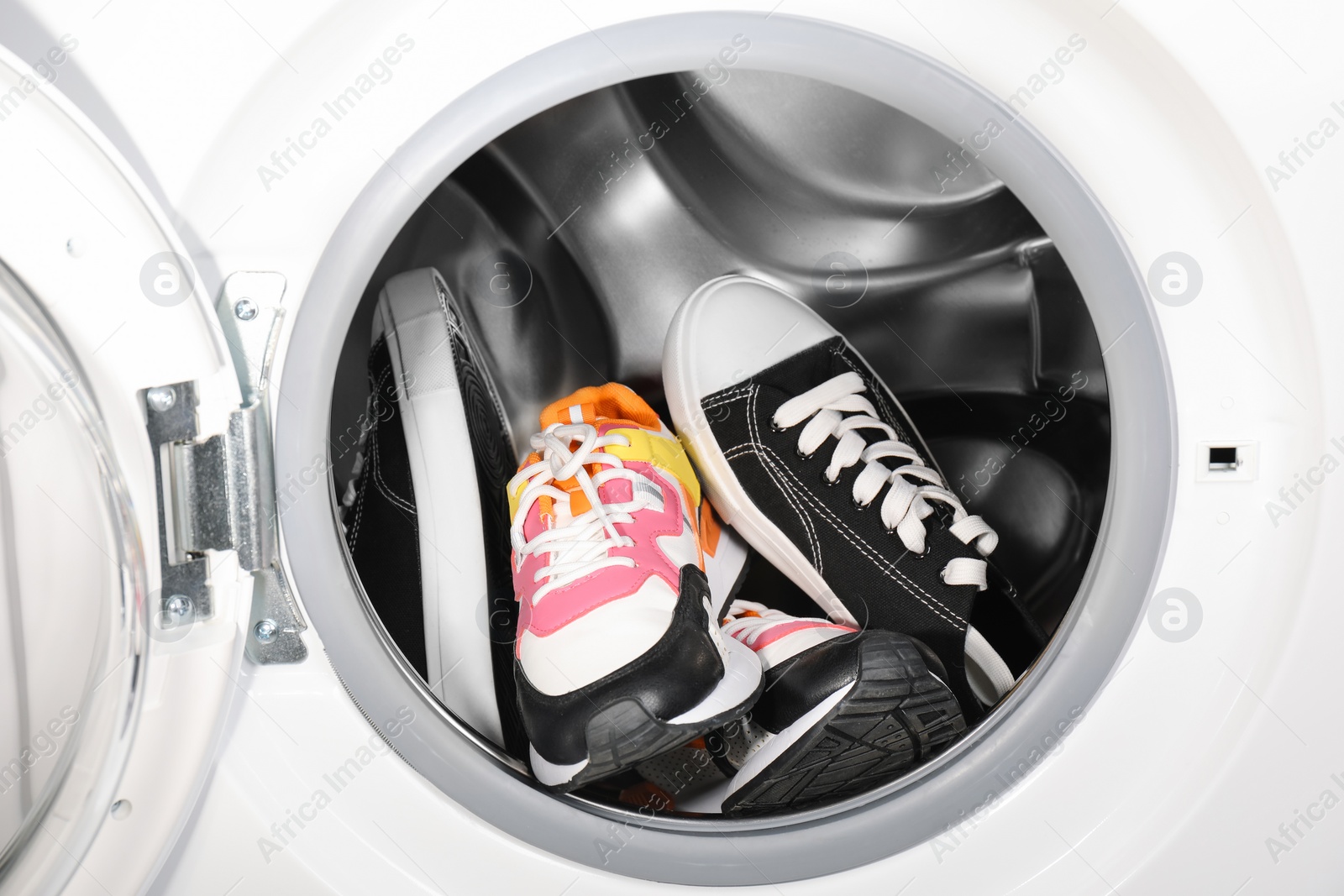 Photo of Different clean sneakers inside modern washing machine