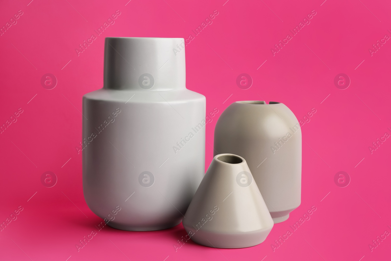 Photo of Stylish empty ceramic vases on pink background