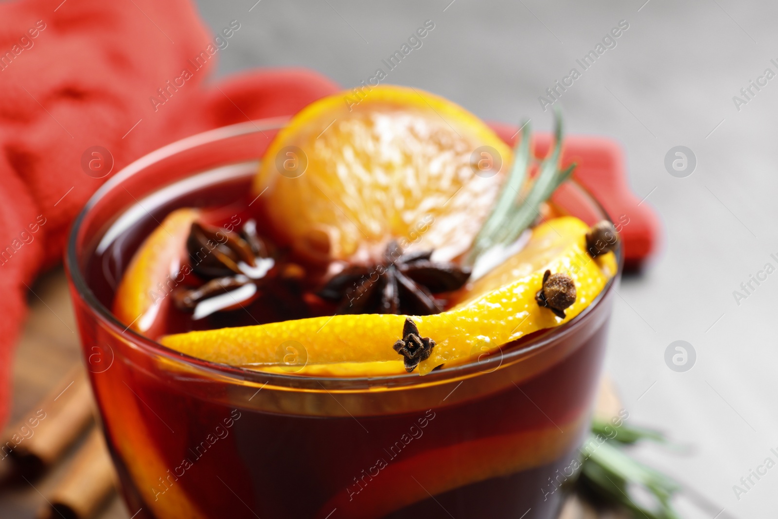 Photo of Glass with aromatic mulled wine on table, closeup