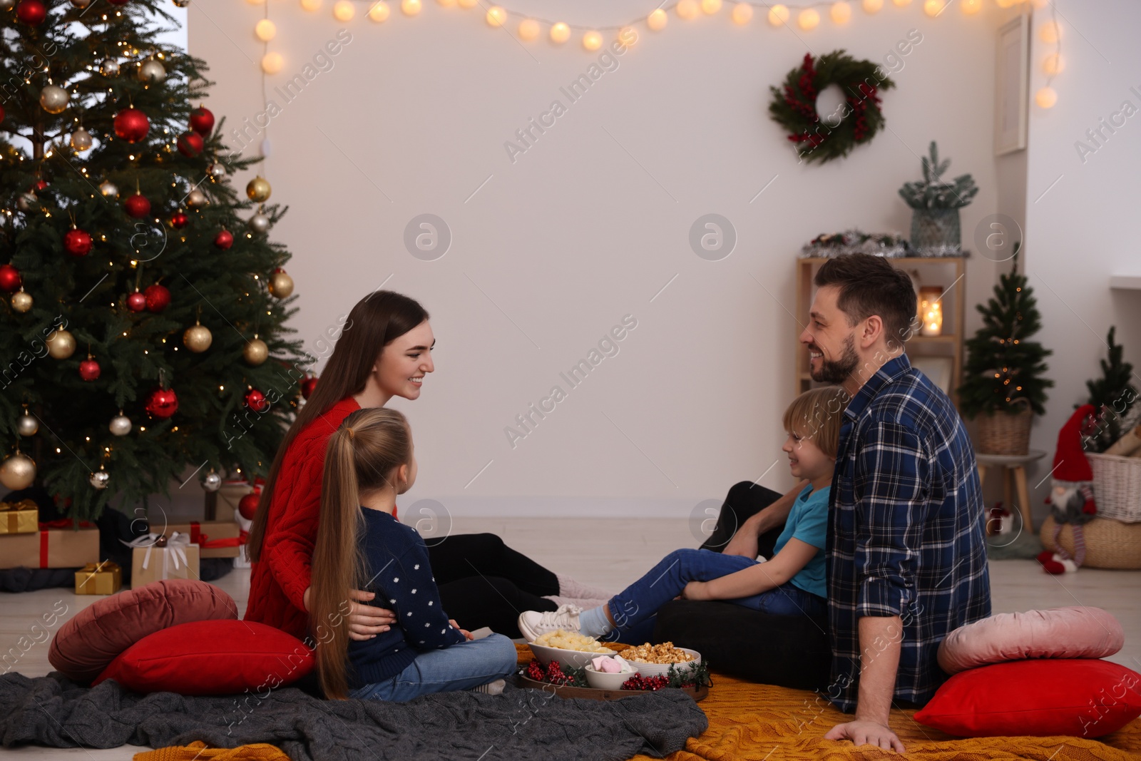Photo of Family spending time together at TV area in cosy room. Christmas atmosphere