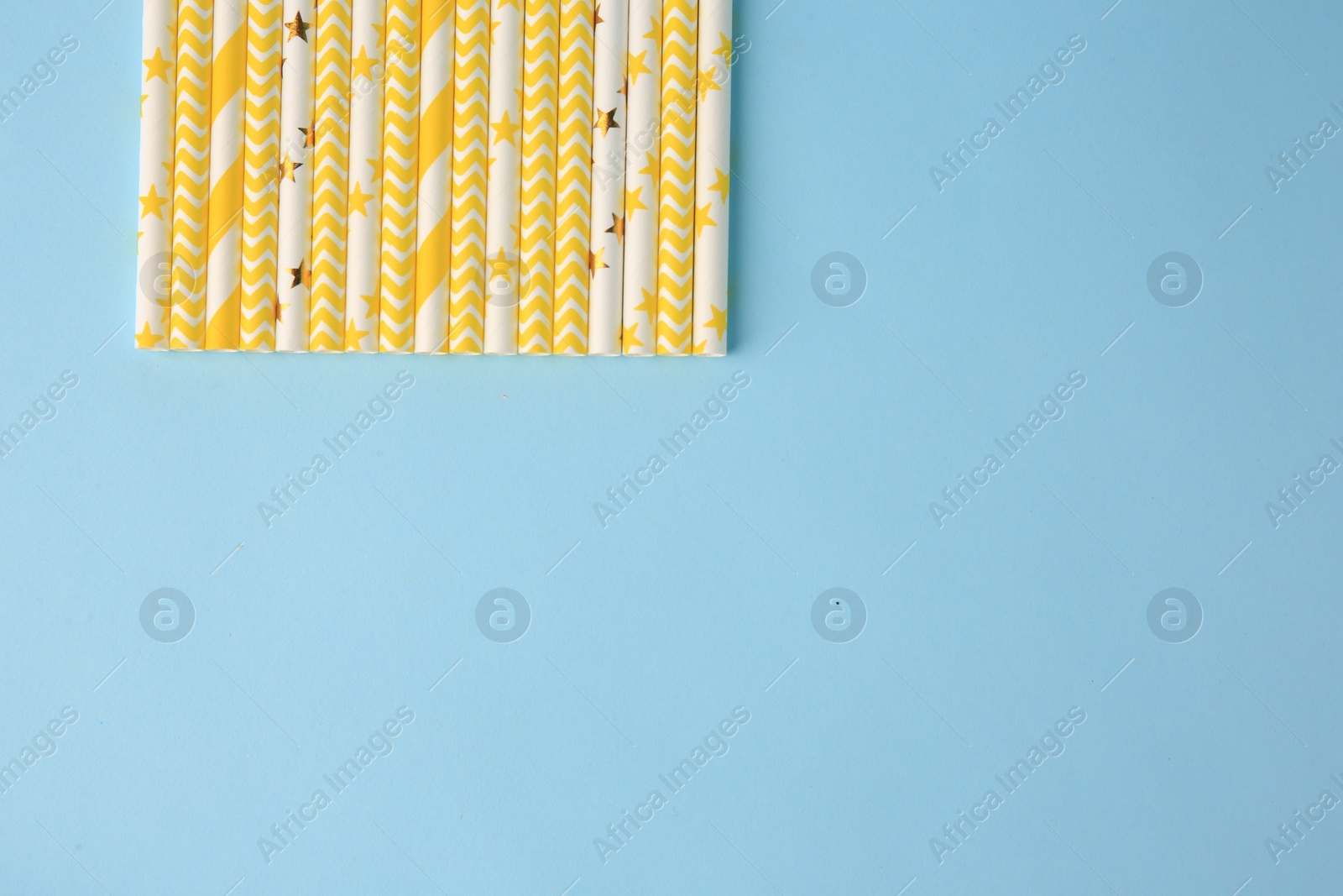 Photo of Many paper drinking straws on light blue background, flat lay. Space for text