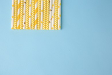 Photo of Many paper drinking straws on light blue background, flat lay. Space for text