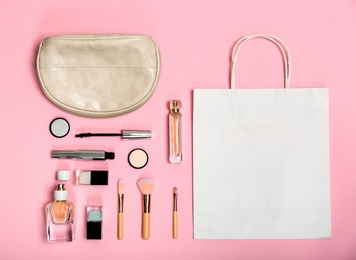 Flat lay composition with shopping bag and cosmetics on color background