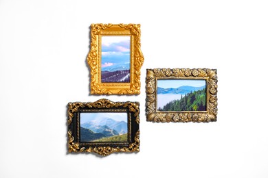 Vintage frames with photos of beautiful landscapes hanging on white wall