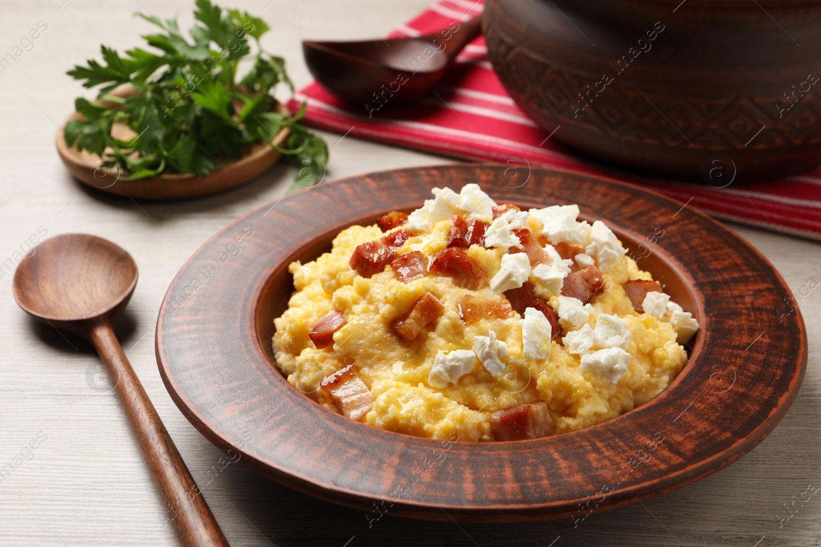 Photo of Delicious traditional Ukrainian banosh served on light wooden table