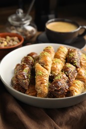 Delicious sweet baklava in bowl on table