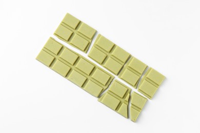 Photo of Pieces of tasty matcha chocolate bars on white background, top view