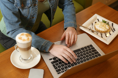 Photo of Blogger working with laptop in cafe, above view