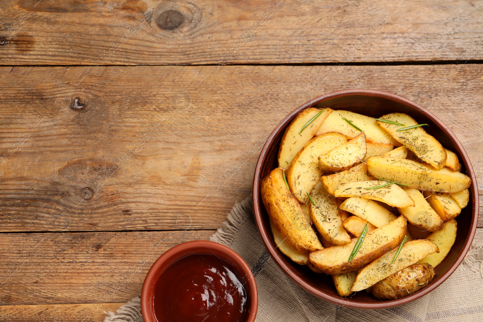 Photo of Delicious baked potatoes with spices and tomato sauce on wooden table, flat lay. Space for text