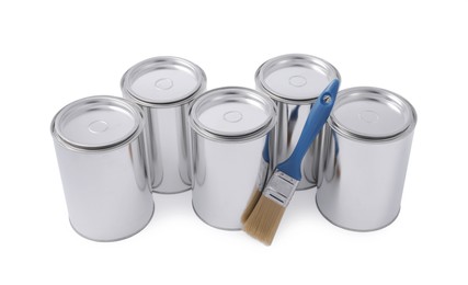 Cans of paints and brush on white background