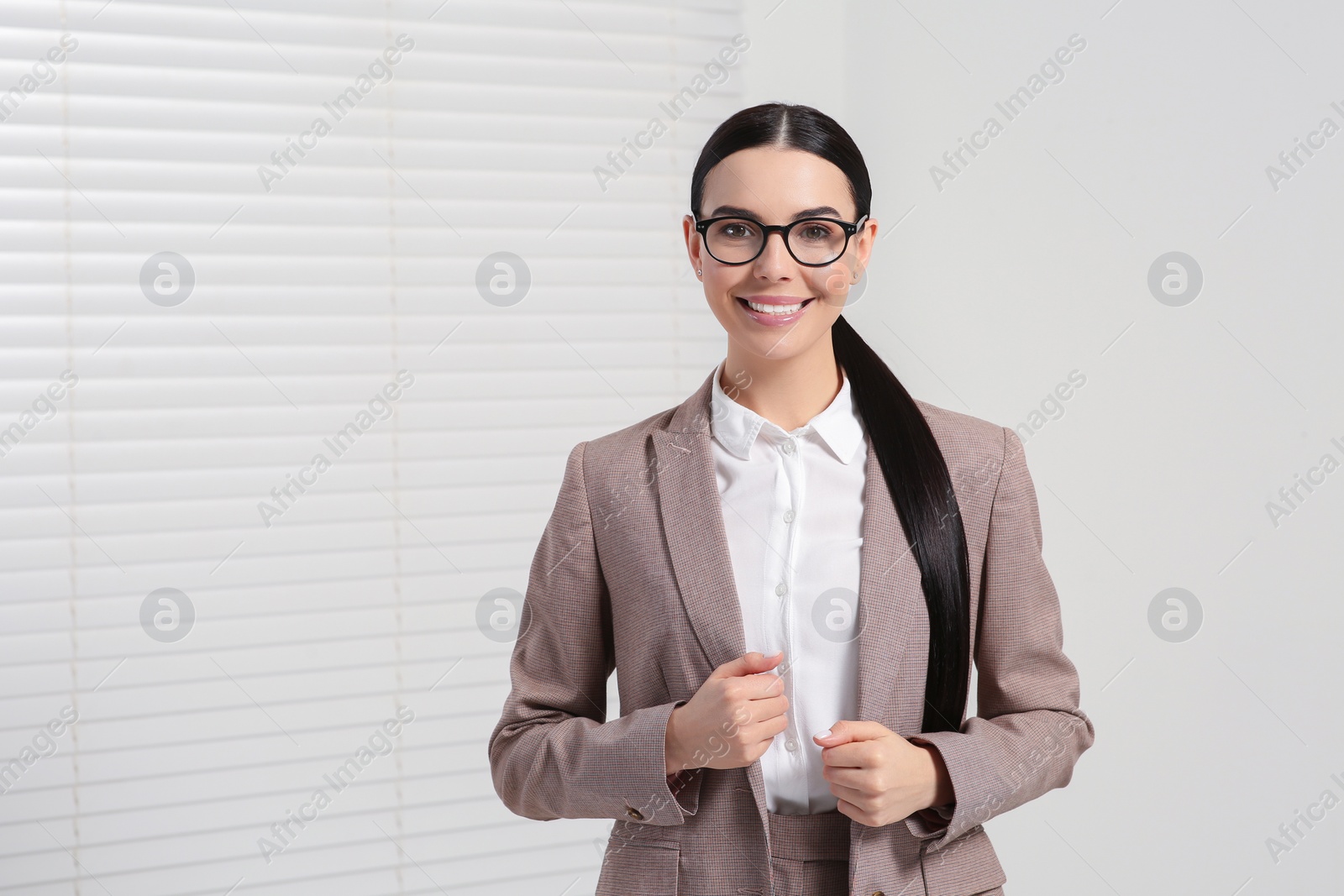 Photo of Beautiful real estate agent in nice suit indoors, space for text