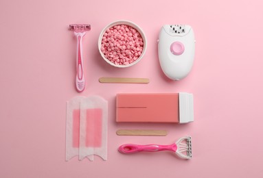 Photo of Set of epilation tools and products on pink background, flat lay