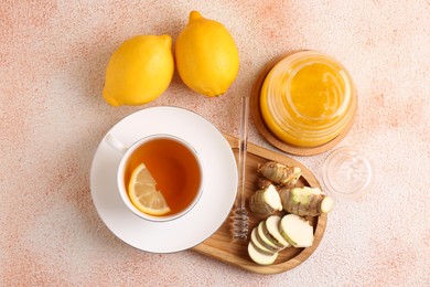 Photo of Flat lay composition of tea, honey, lemon and ginger on beige textured table
