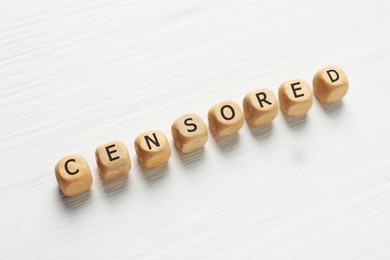 Photo of Wooden cubes with word Censored on white table