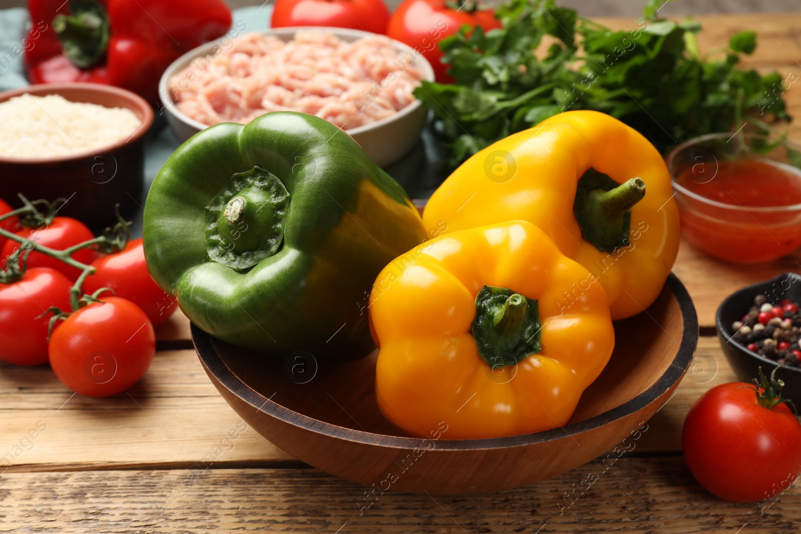 Photo of Making stuffed peppers. Vegetables and ground meat on wooden table, closeup