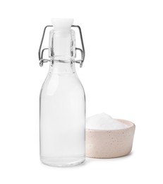 Photo of Vinegar in glass bottle and baking soda isolated on white