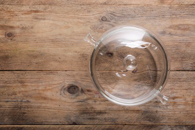 Photo of Glass pot with lid on wooden table, top view