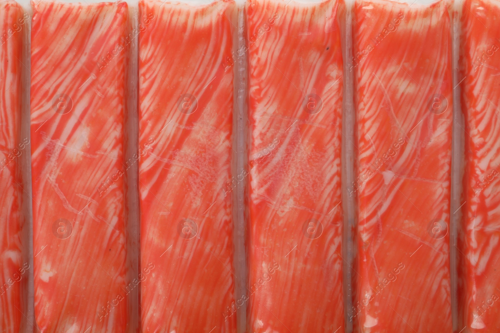 Photo of Top view on fresh crab sticks in pack as background, closeup