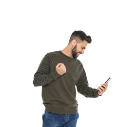 Photo of Happy young man with smartphone celebrating victory on white background