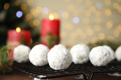 Photo of Tasty snowball cookies on cooling rack, closeup. Christmas treat