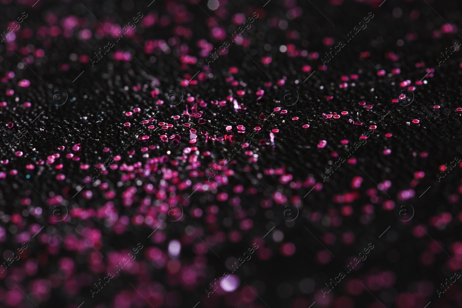 Photo of Pink glitter with bokeh effect on dark background