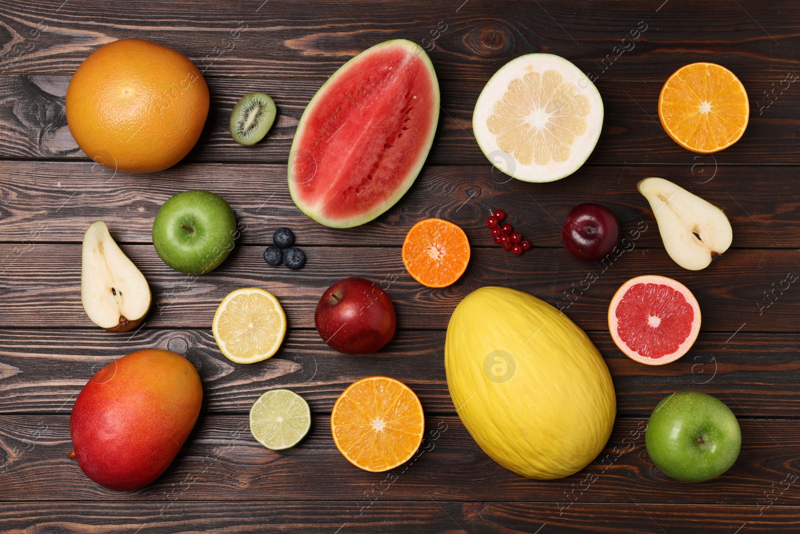 Photo of Different ripe fruits and berries on wooden table, flat lay