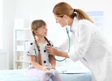 Photo of Children's doctor examining little girl in hospital
