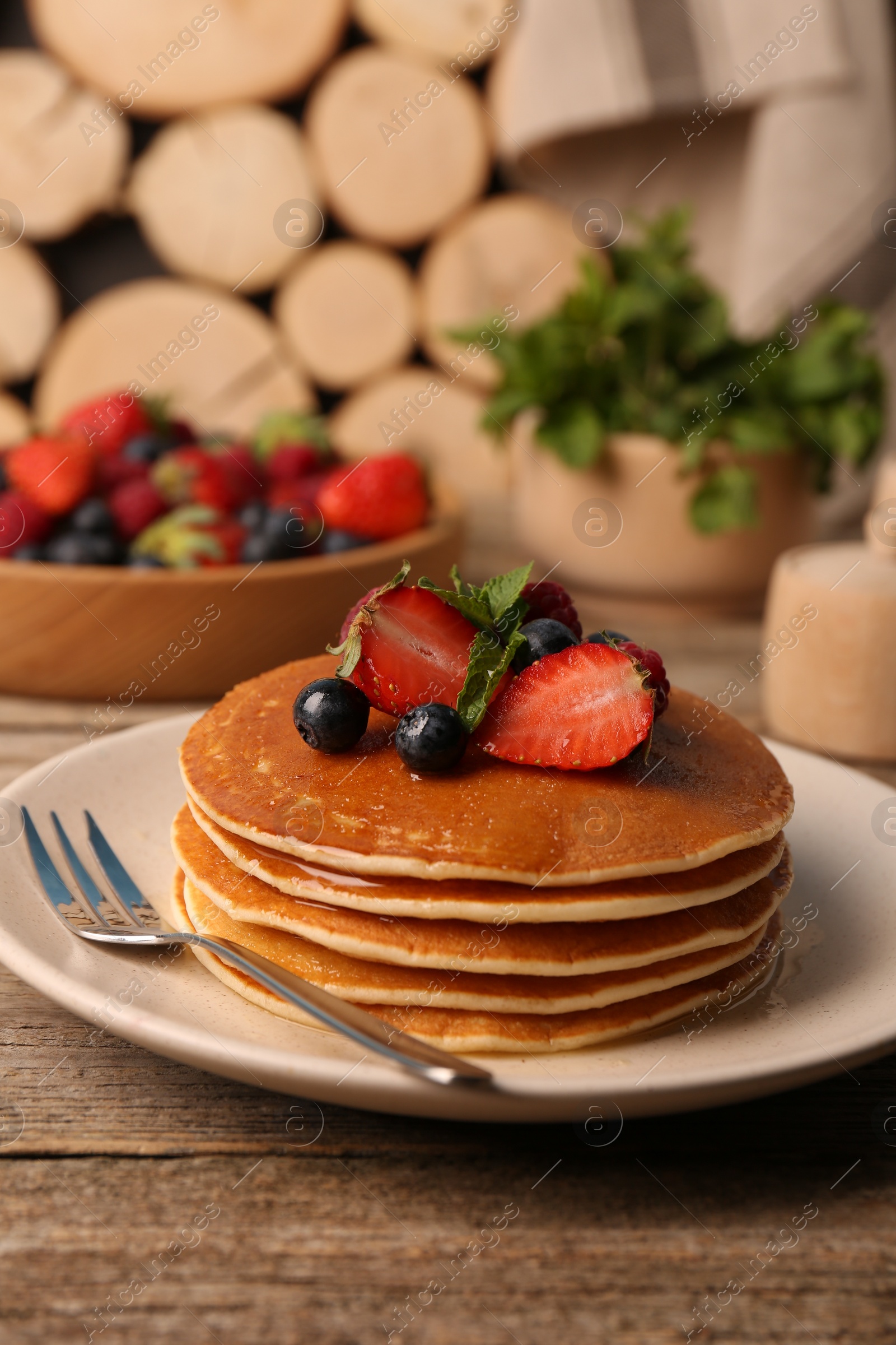 Photo of Tasty pancakes with fresh berries and mint on wooden table