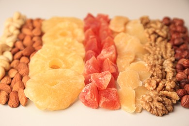 Different tasty nuts and dried fruits on beige background, closeup