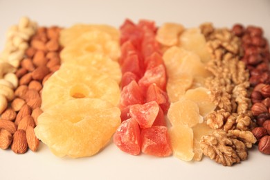 Photo of Different tasty nuts and dried fruits on beige background, closeup