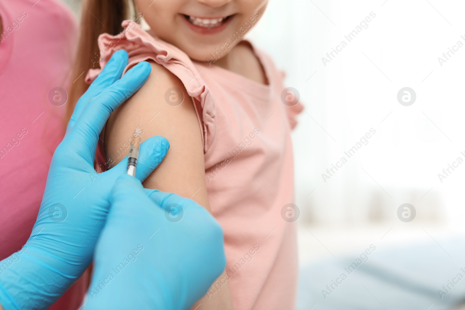 Photo of Children's doctor vaccinating little girl, closeup. Space for text