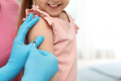 Photo of Children's doctor vaccinating little girl, closeup. Space for text
