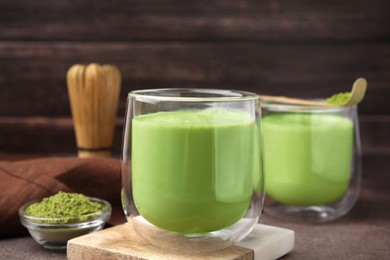 Photo of Glass of tasty matcha smoothie on brown table, closeup