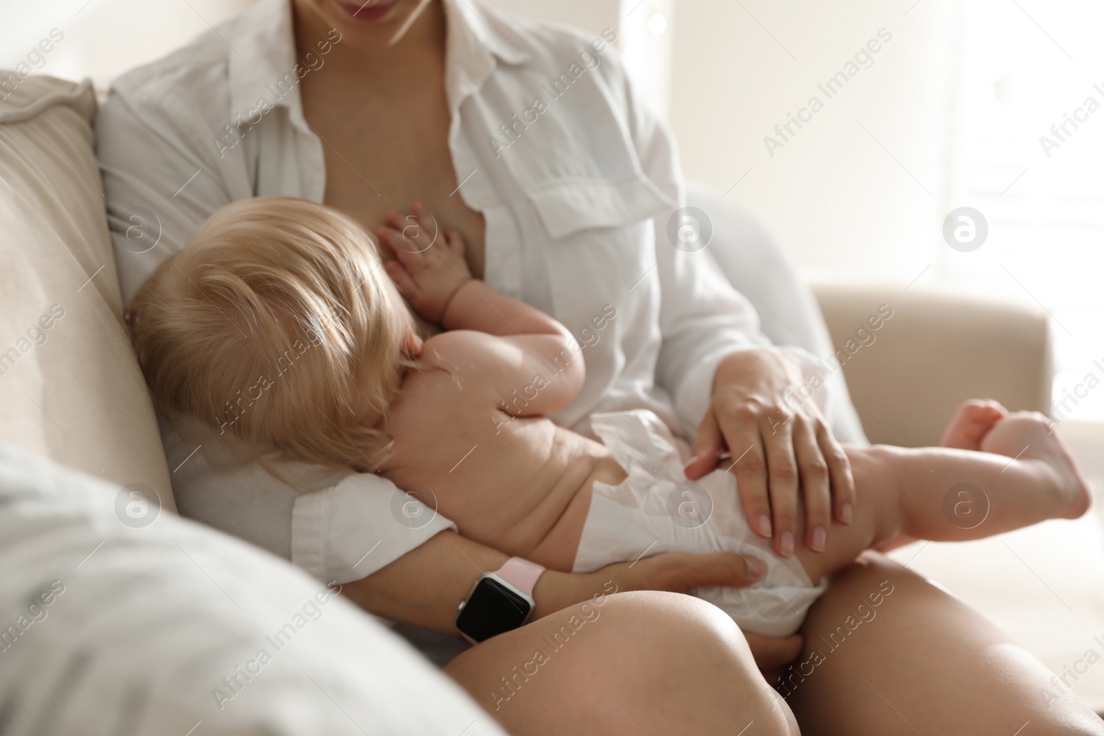 Photo of Mother breastfeeding her little baby at home. Healthy growth