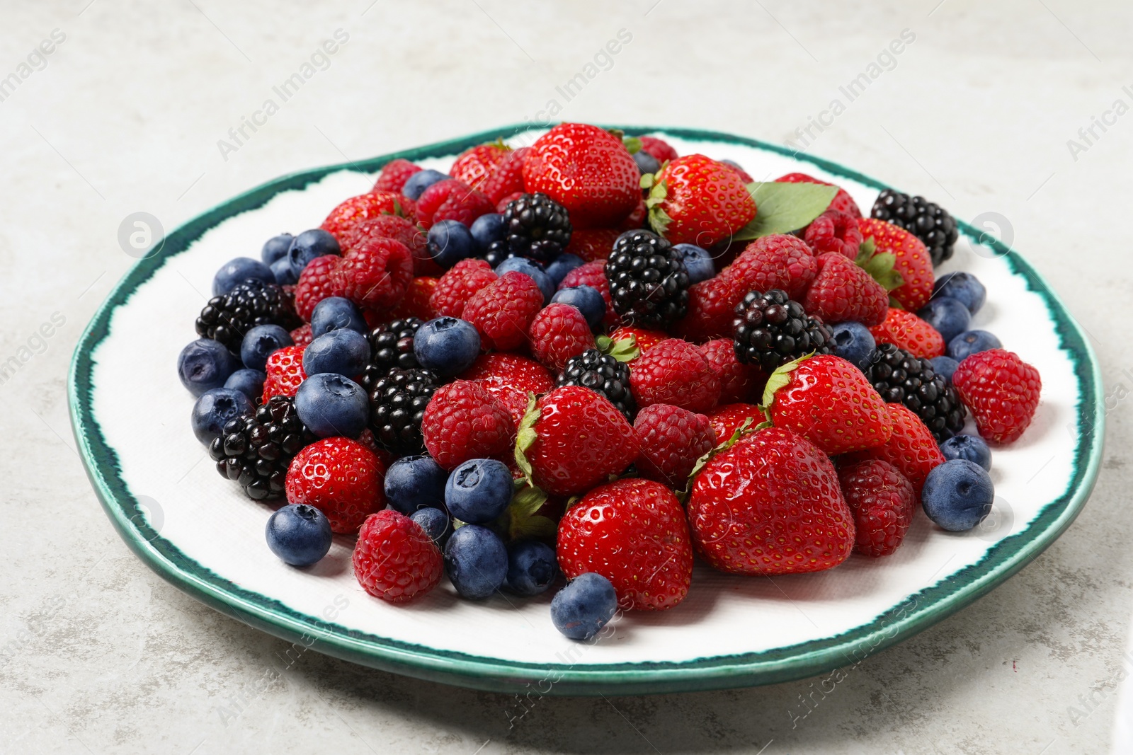 Photo of Different fresh ripe berries on light grey table, closeup