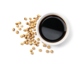 Photo of Tasty soy sauce in bowl and soybeans isolated on white, top view