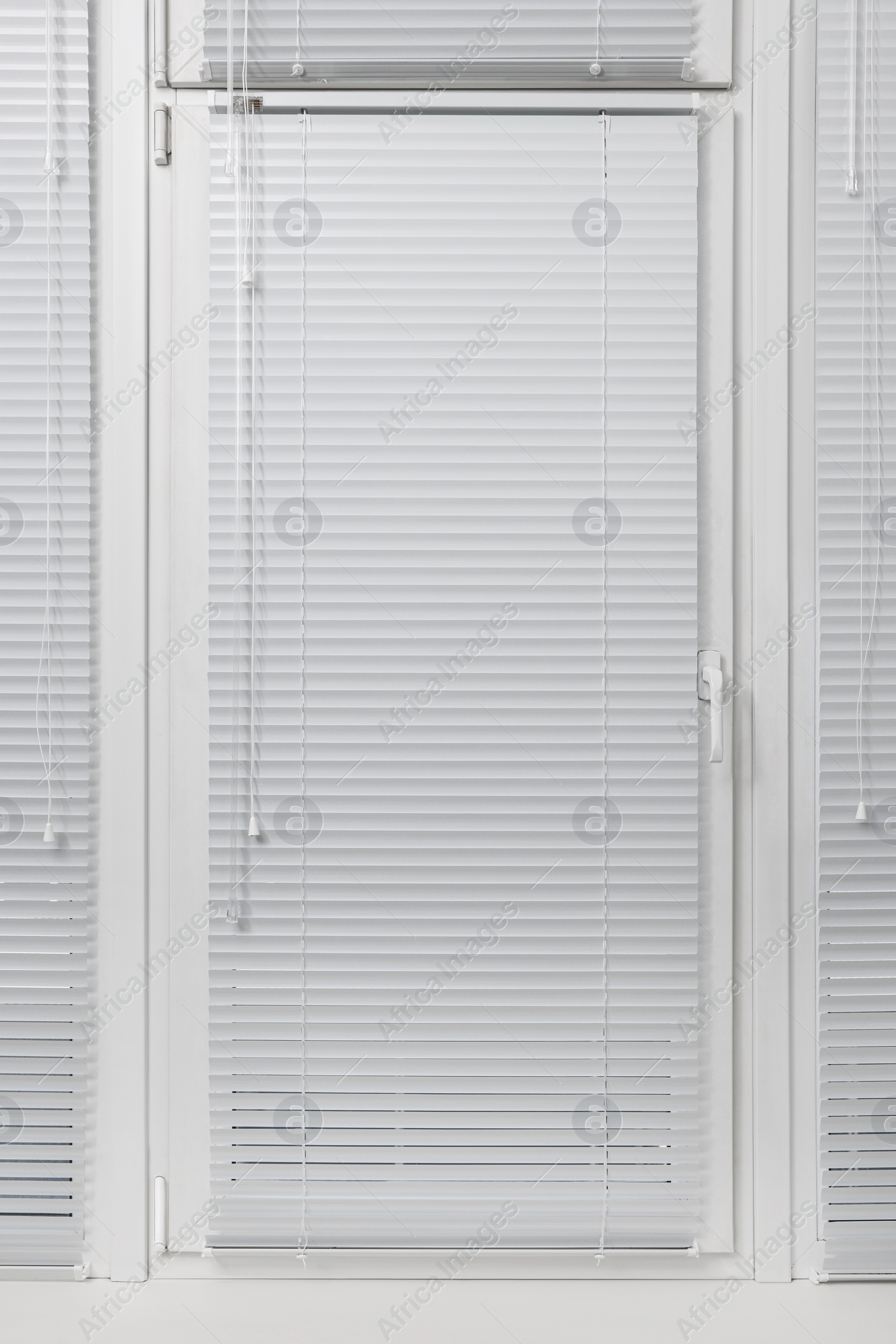 Photo of Window with closed white horizontal blinds indoors