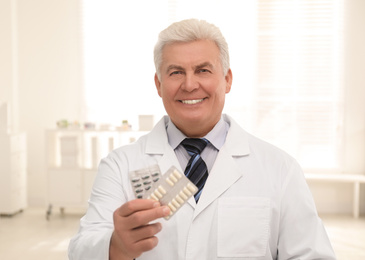 Photo of Portrait of senior pharmacist with pills in drugstore