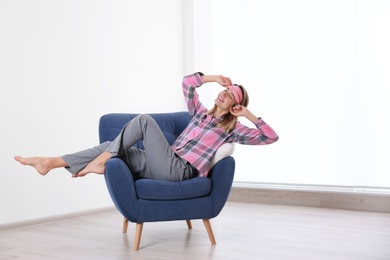 Photo of Young woman relaxing in armchair at home. Space for text