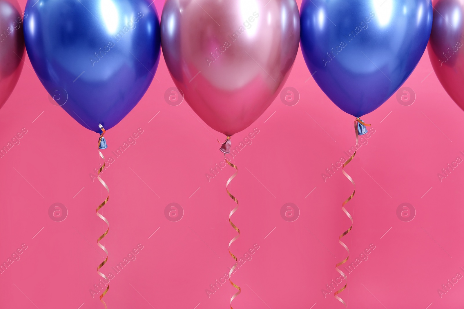 Photo of Bright balloons with ribbons on color background. Space for text