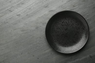 Photo of Beautiful ceramic plate on black table, top view. Space for text